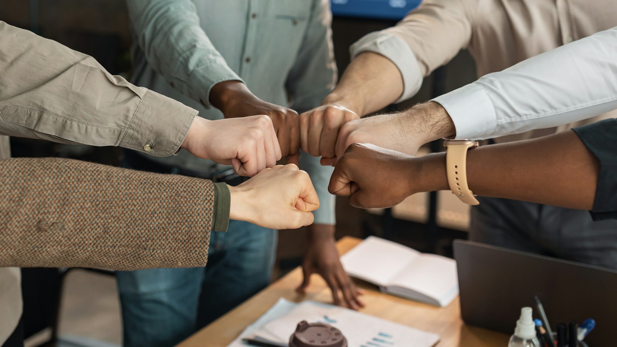 Portrait of diverse business people giving fist bump in circle